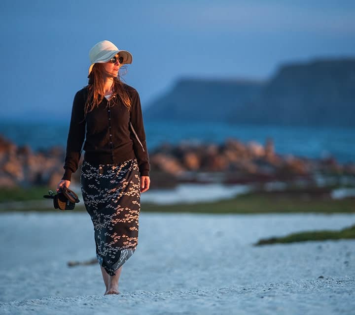 Woman walking on Galapagos beach at sunset