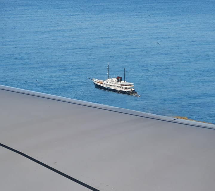 Airplane window view of Evolution Yacht in Galapagos
