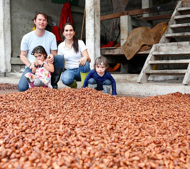 Family standing over a gold mine of cacao beans