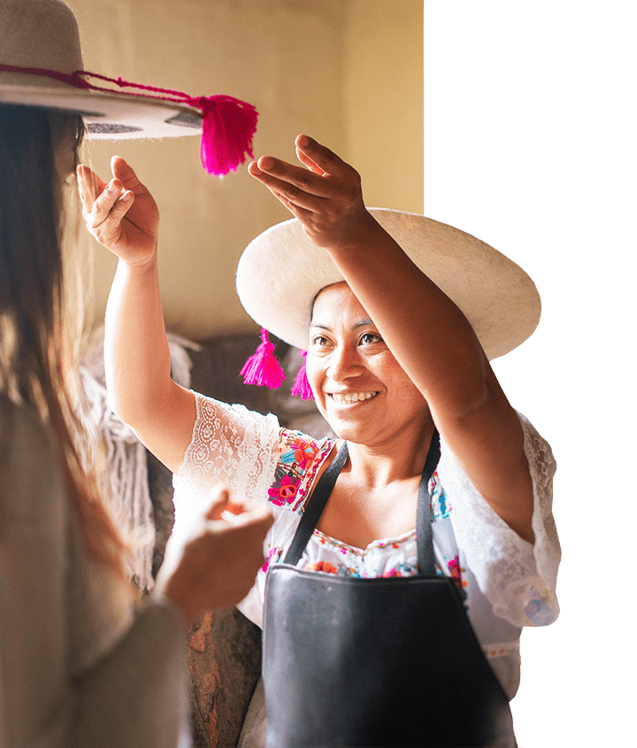 Ecuadorian woman placing hat on traveler