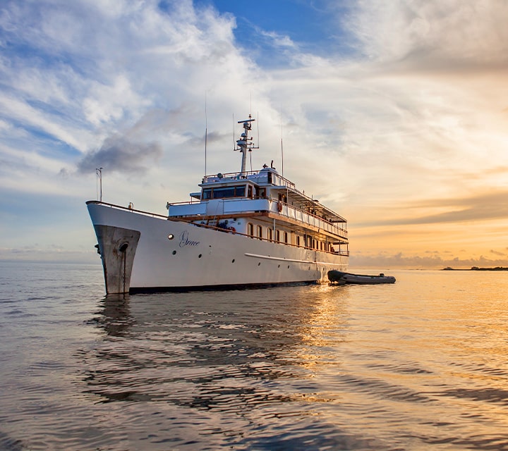 Monohull yacht, M/Y Grace, anchored on calm still waters within the Galapagos Islands