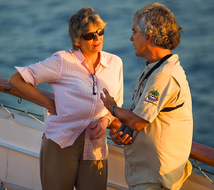 Founder, Dolores Gangotena, and Roberto, Quasar's Certified Naturalist Guide, discussing logistics aboard a Quasar Expedition yacht