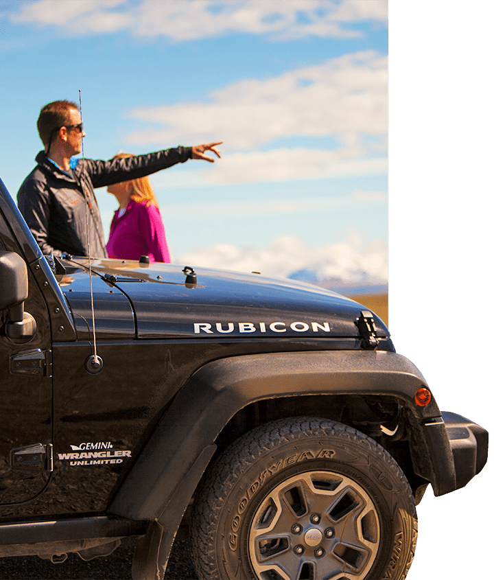 A man pointing into the distance next to a Jeep Rubicon on a Patagonia Safari