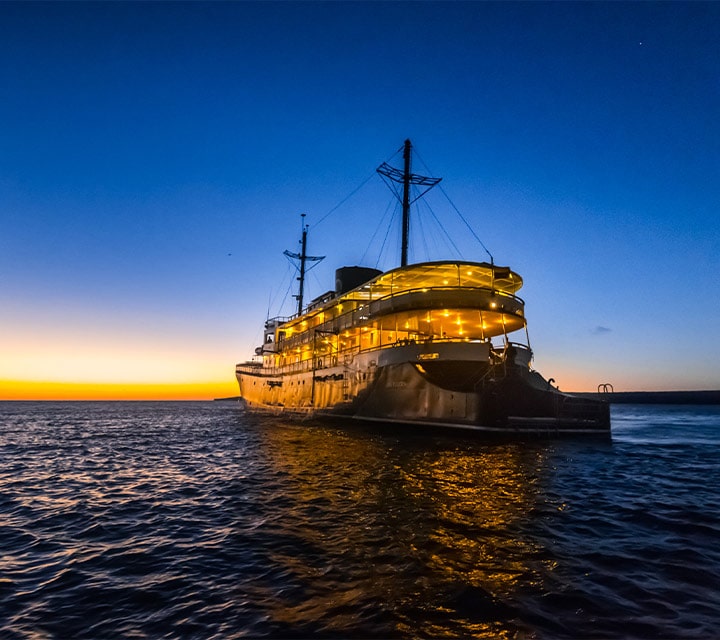 Travel+Leisure's World's Best Small-ship Ocean Cruise Line in the World in 2018, 2019, 2020, and now 2021 Evolution Yacht sailing at sunset in the Galapagos Islands