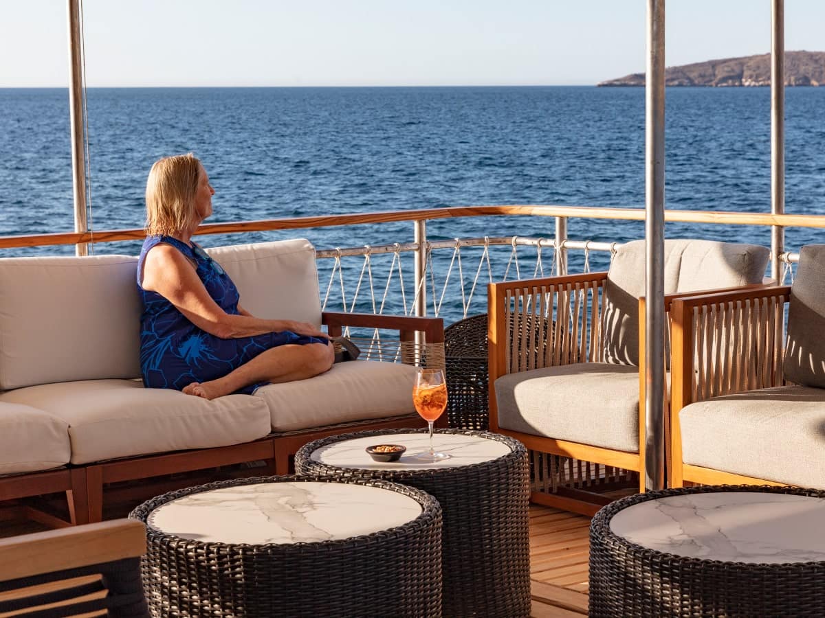 Woman lounging with cocktail aboard M/Y Grace