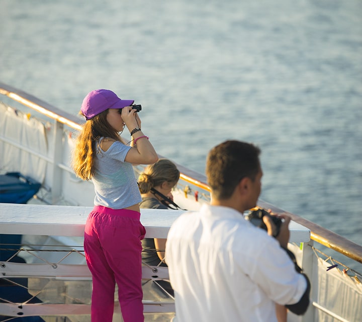 Family on a Galapagos cruise looking through binoculars