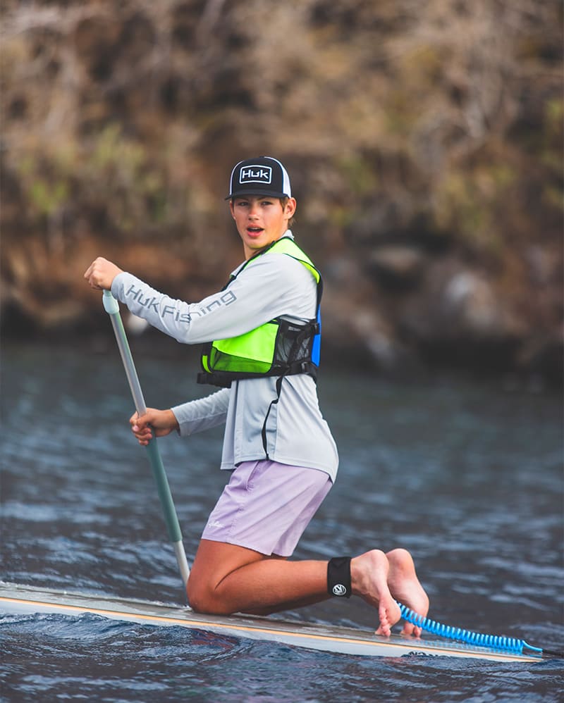 Young man enjoys paddleboarding in the Galapagos waters