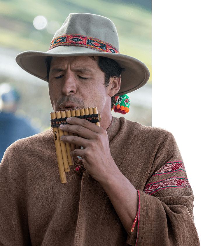 Peru local playing a traditional pan flute made of bamboo pipes